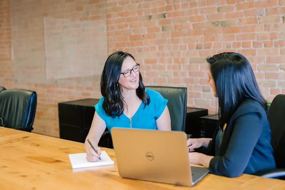 Brown-skinned professional presenting to a small panel