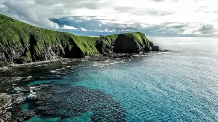 Rocky Fiji shoreline and green hills