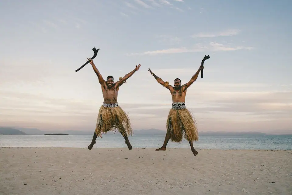 Young Fijian men on a sandy beach