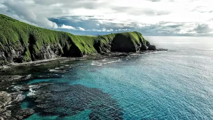 Rocky Fiji shoreline and green hills
